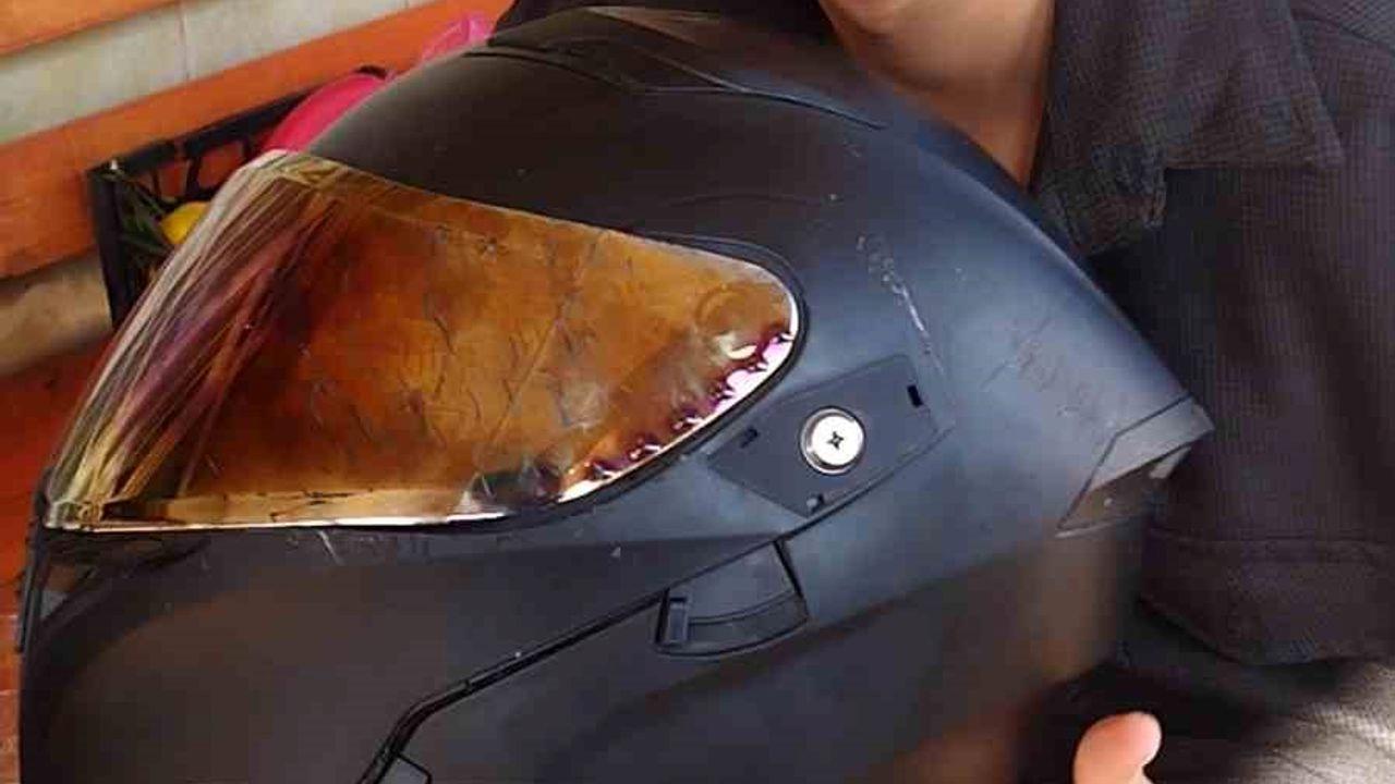 Kaskla yaşama tutunan motosikletli genç: